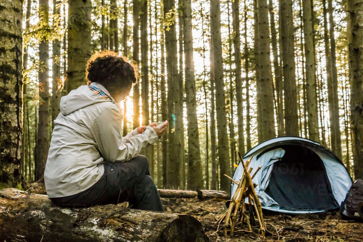 Woman using mobile phone while camping